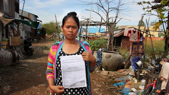 Cambodian surrogate mother Hour Vanny, holding the two-page document she signed with Fertility Solutions, operated by Australian nurse Tammy Davis-Charles. 