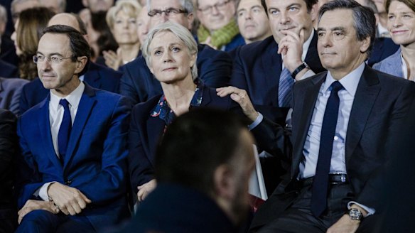 Francois Fillon, France's presidential candidate, right, puts a hand on the shoulder of his wife, Penelope Fillon, in Paris.
