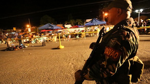 A Philippine soldier keeps watch at the bombing site in Davao, Philippines on Friday.