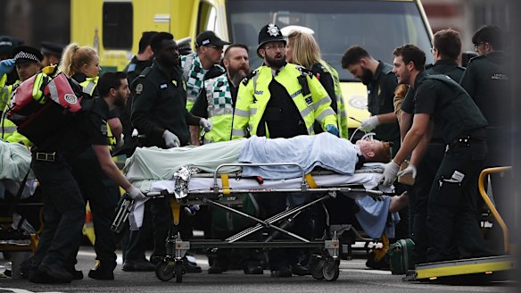 A member of the public is treated by emergency services near Westminster Bridge after the attack.