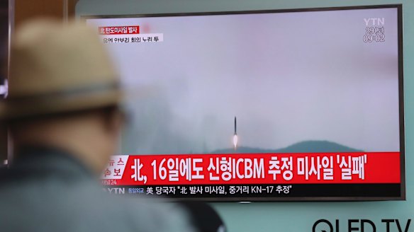 A man watches a TV news program reporting a North Korean missile test.