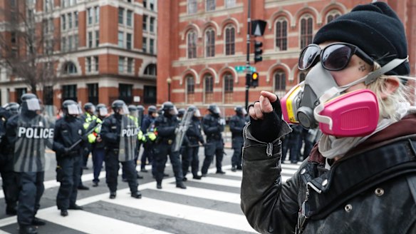 A protester faces off with a line of riot police in Washington, DC, during the inauguration.