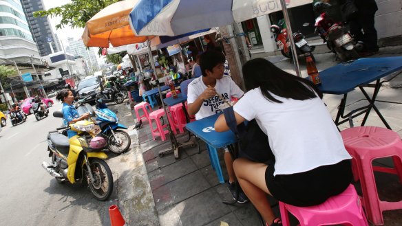 Lunch time: People eat noodles at a street food stall on Thonglor road, Bangkok, Thailand. Officials see street food as an illegal nuisance.