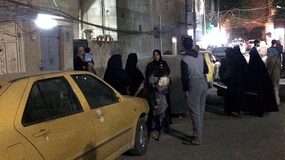 People stand in the street after feeling aftershocks in Baghdad, Iraq.