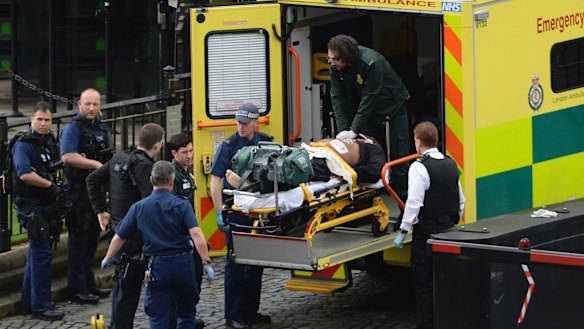 An attacker is treated by emergency services outside the Houses of Parliament in London.