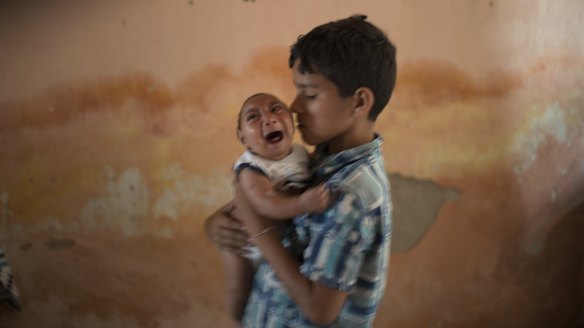 Ten-year-old Elison nurses his two-month-old brother Jose Wesley at their house in Poco Fundo, Pernambuco state, Brazil.