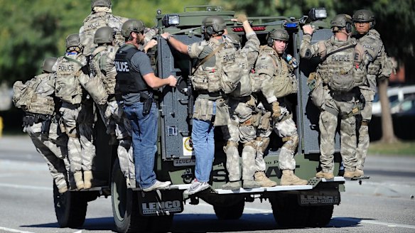 A SWAT vehicle carries police officers near the scene of a shooting in San Bernardino.