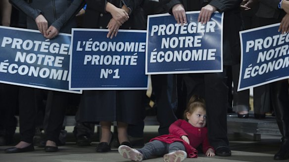 A young girl lies on the ground as Canadian Conservative leader Stephen Harper addresses the crowd at a campaign event in Quebec City on Friday. 