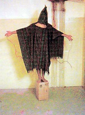 A hooded detainee at Abu Ghraib prison.