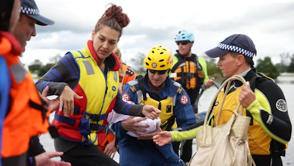 A young mother and her seriously ill four-month old baby are taken across the water in an inflatable boat.