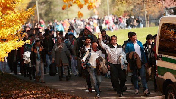 German police lead arriving refugees from Wegsheid, near the Austrian border to a transport facility on Wednesday.