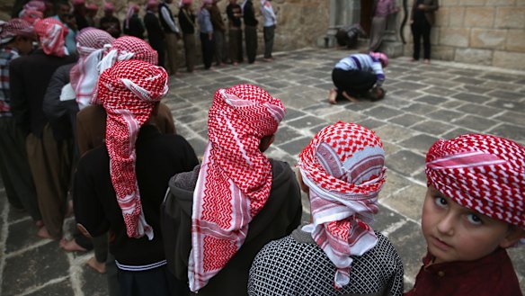 Yazidi boys line up to pray at their religion's most holy temple on November 6, in Lalish, Iraq. Many Yazidi visitors to the Lalish temple were displaced from Sinjar Mountain, overrun by IS in 2014, when IS killed thousands of the men and enslaved many Yazidi women. 