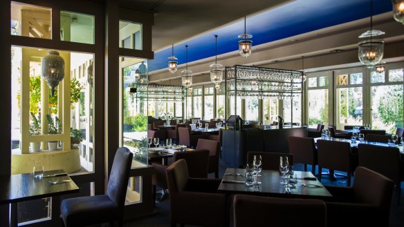 The light-filled dining room features hanging lanterns.