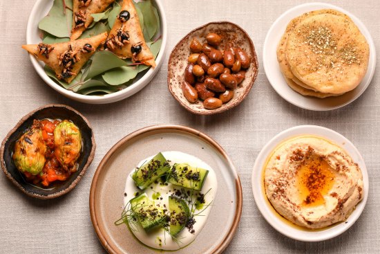 The opening flurry of snacks starring Turkish breads, hummus, and arak cucumbers.