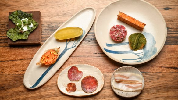 Clockwise from left: Green chip and ricotta; fermented gherkin with beetroot and cheese tart; whey carrot, smoked trout on rye, salt and vinegar dutch cream potato; pancetta; and salami. 