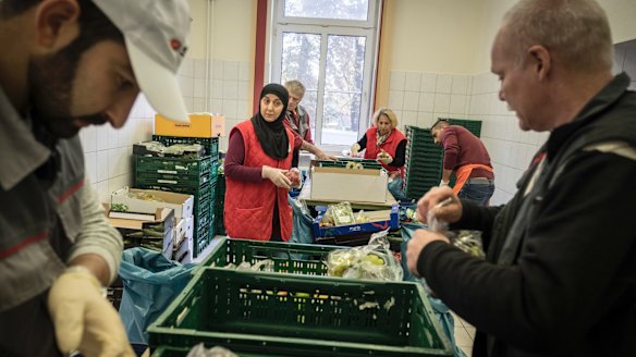 Nadja Haj Mohamad, centre, and other Germans sort through delivered food at the Tafel food bank headquarters in Bremerhaven, which has seen a sevenfold increase in the number of people served since Angela Merkel came to power.