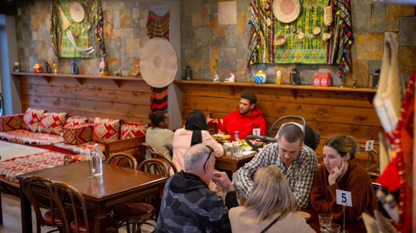 Diners sit on rugs or at tables at Mandina Kitchen in Carlton.