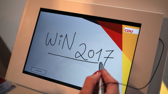 A visitor writes "Win 2017" on a touch screen pad ahead of the German elections.