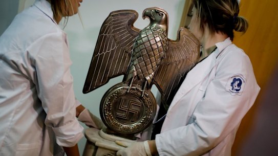 Members of Argentinian federal police carry a Nazi statue found hidden in a house in Buenos Aires.