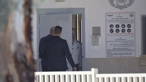 Ehud Olmert, left, enters prison to begin his sentence in the central Israeli town of Ramle.