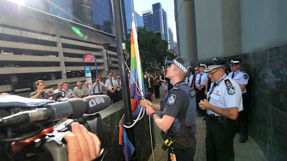 Transgender police officer Mairead Devlin raises the rainbow flag for the first time outside QPS headquarters.