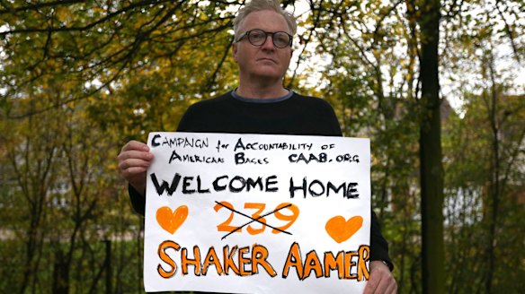 A supporter holds a placard after Shaker Aamer arrived at Biggin Hill Airport, England, on Friday.