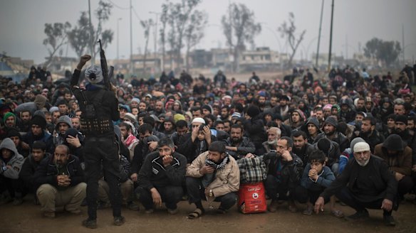 Displaced Iraqis, fleeing fighting between Iraqi security forces and Islamic State militants, wait for a security check before being transferred to a camp on the western side of Mosul.