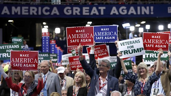 Delegates hold up signs and cheer during first day of the Republican National Convention.