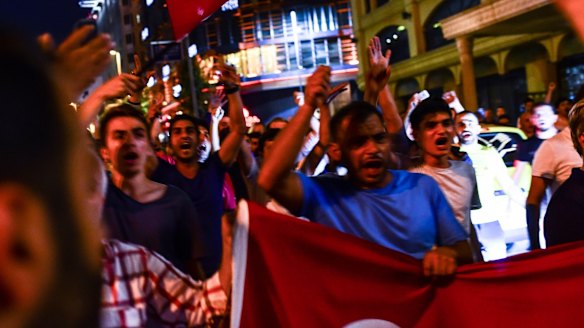 Supporters of Turkish President Recep Tayyip Erdogan march in the main streets of Istanbul, in the early morning hours of Saturday.