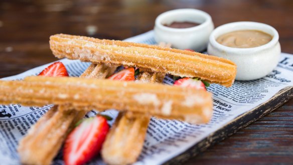 Churros served with little pots of chocolate and salted caramel.