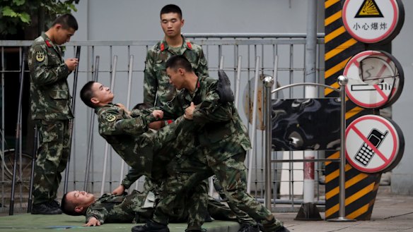 Chinese paramilitary policemen practise self-defence in Beijing. China is warning India not to underestimate its determination to safeguard what it considers sovereign territory.