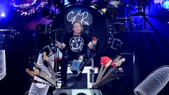 Nursing a broken foot, Axl Rose of Guns N' Roses performs on a throne at Coachella on Saturday. His promotion to the job of lead singer for AC/DC has angered fans.