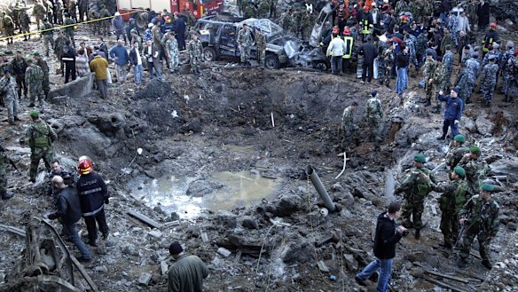 Rescue workers stand around a massive crater after a bomb attack that  killed Lebanese leader  Rafiq Hariri in Beirut on February 14, 2005.
