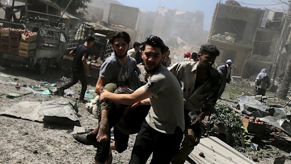 Men transport a casualty after the air strikes on a busy marketplace in Douma.