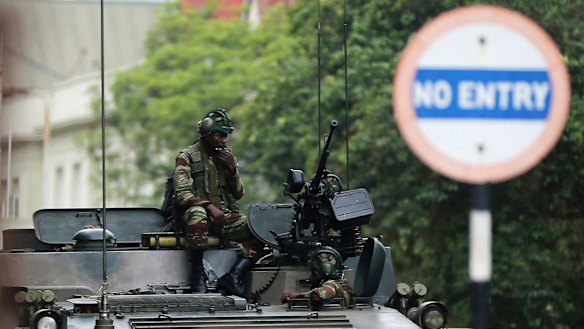 Soldiers sit on a military vehicle parked on a street in Harare, Zimbabwe.