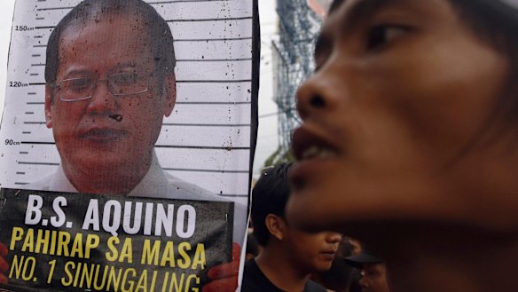 A placard containing an image of Aquino near a protester after demonstrators were blocked from marching towards Batasang Pambansa, where Aquino addressed the nation.