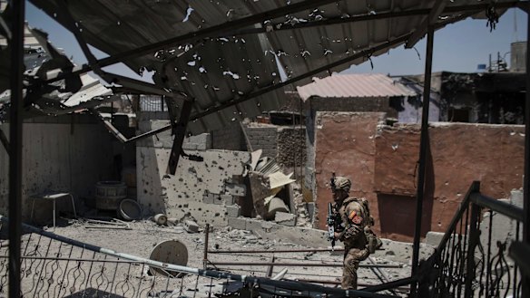 An Iraqi soldier walks by a damaged house during fighting against Islamic State militants in the Old City of Mosul on Tuesday.