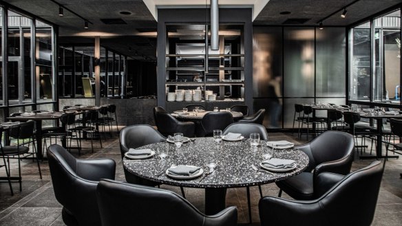 The 400 Gradi fitout contrasts a monochromatic palette with brass details and bronze-framed mirrors.