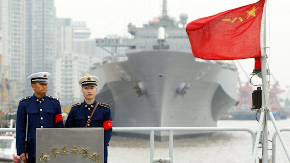 Two Chinese soldiers stand guard on the warship Lianyungang in 2004. 
