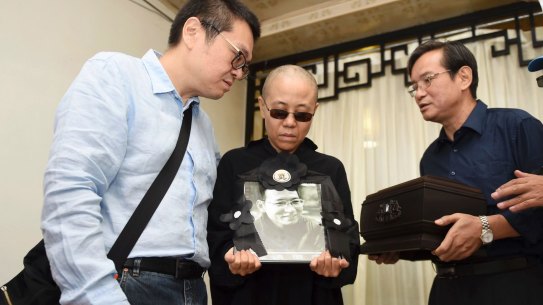 Liu Xia, centre, holds a portrait of her husband Liu Xiaobo during his funeral in Shenyang, north-eastern China, on Saturday.