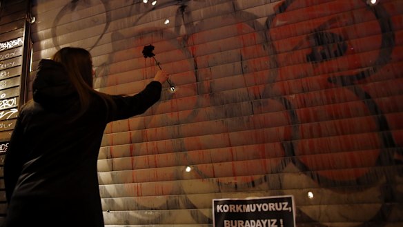 A woman leaves a carnation at the explosion site at Istanbul's landmark Taksim Square, close to the scene of an explosion.