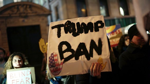 A man holds a placard during a gathering in Paris to protest US President Donald Trump's recent travel ban.