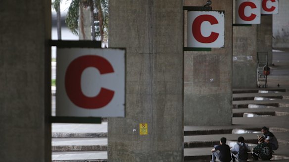 People wait at a deserted bus station after a protest in Brasilia on Friday.