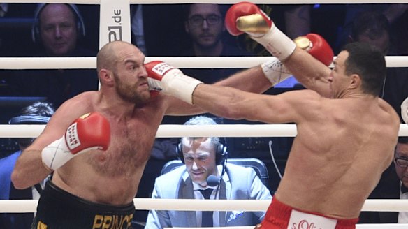 Battle of the big men: Ukraine's Wladimir Klitschko, right, and Britain's Tyson Fury exchange blows in their world heavyweight title fight for Klitschko's WBA, IBF, WBO and IBO belts in the Esprit Arena in Duesseldorf, Germany.