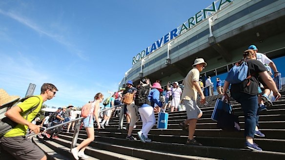 Tennis fans  rush into Rod Laver Arena on the first day of the Australian Open on Monday.