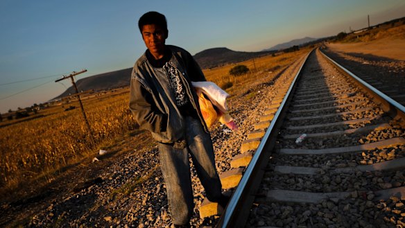 A Guatemalan asylum seeker waits on railroad tracks to climb on a cargo train bound for Mexico and the US. 