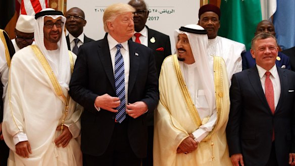 President Donald Trump talks with Saudi King Salman as they pose for photos with leaders at the Arab Islamic American Summit.