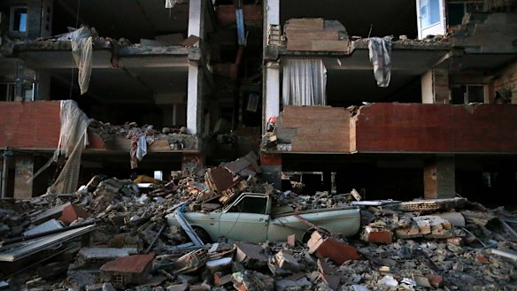 A car lays smashed by debris from the earthquake at the city of Sarpol-e-Zahab in western Iran.