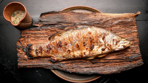 Paperbark-wrapped whole barramundi with clam veloute.