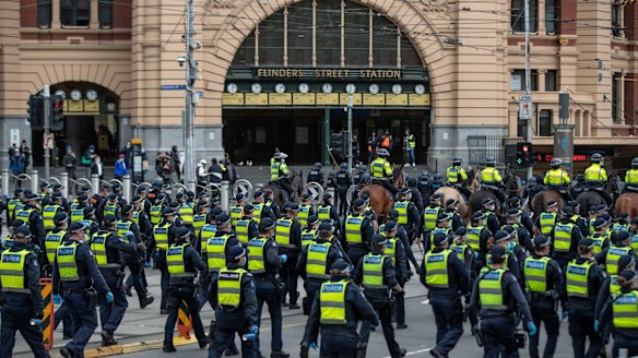 Police are seen outside Flinder Street Station today. 